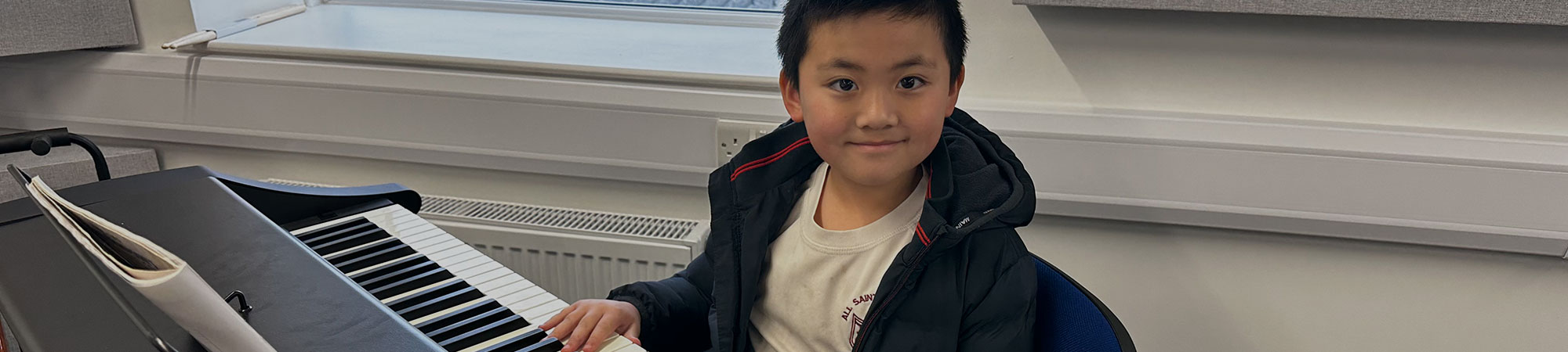 Child learning to play piano at Wrexham Sounds