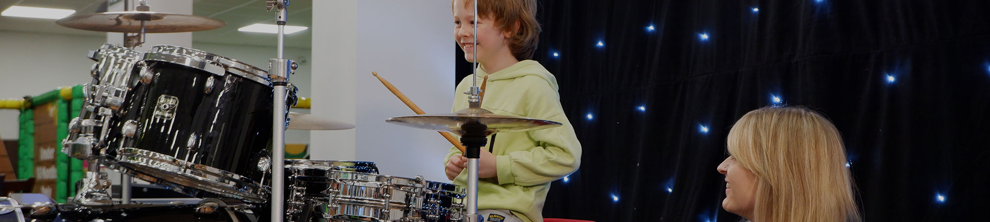 Young boy playing drums at Wrexham Sounds