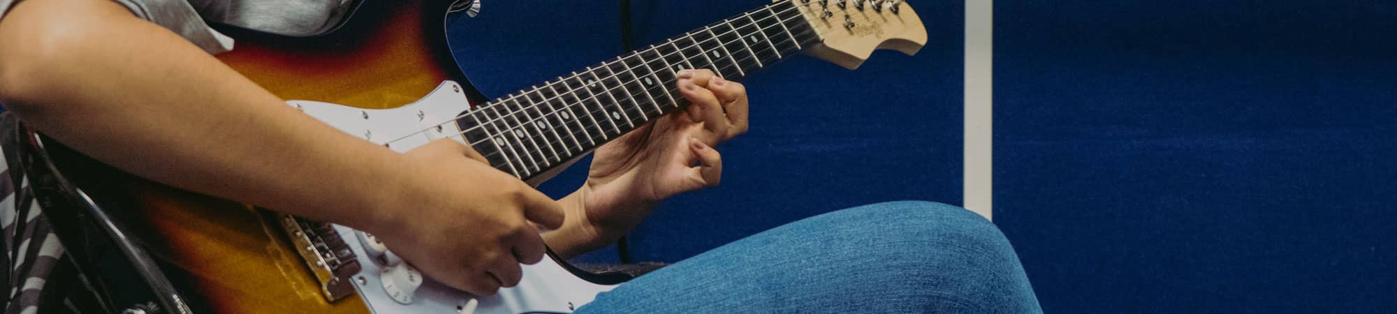 Child learning electric guitar in Wrexham