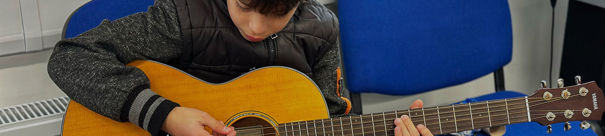 Boy playing acoustic guitar
