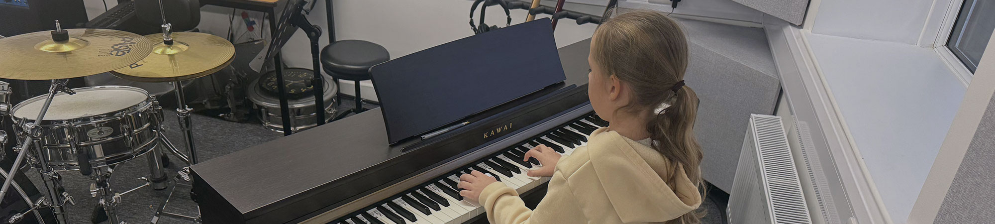 Young girl playing piano in Wrexham