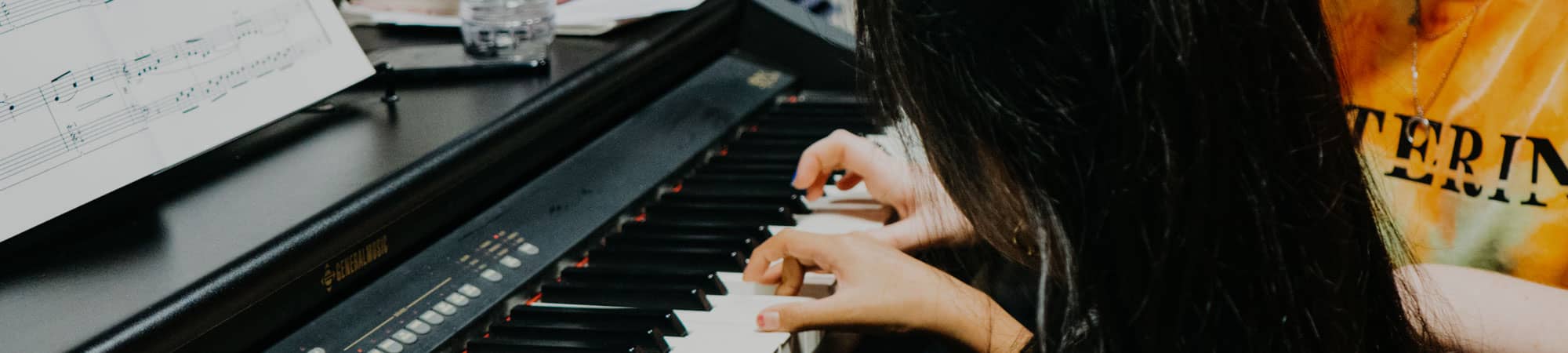 Child learning to play piano at Wrexham Sounds