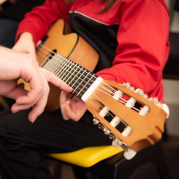 Child learning acoustic guitar
