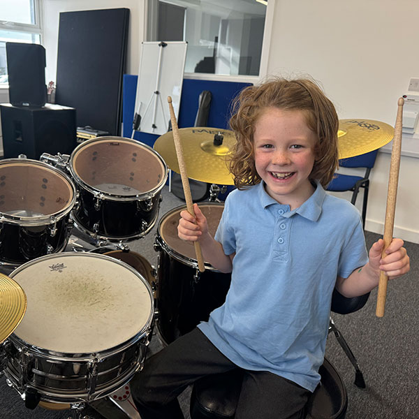 Young boy with drums teacher in Wrexham