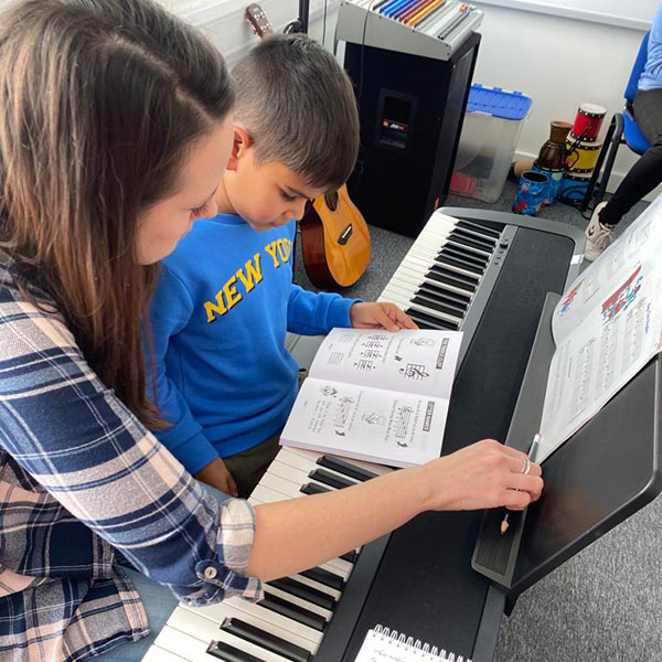 Young boy with keyboard teacher in Wrexham