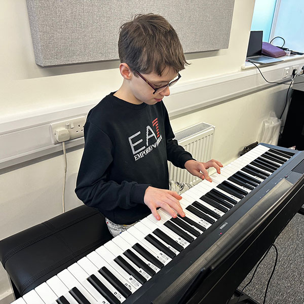 Young boy learning to play drums at Wrexham Sounds