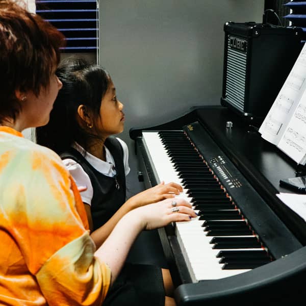 Young girl with piano teacher in Wrexham