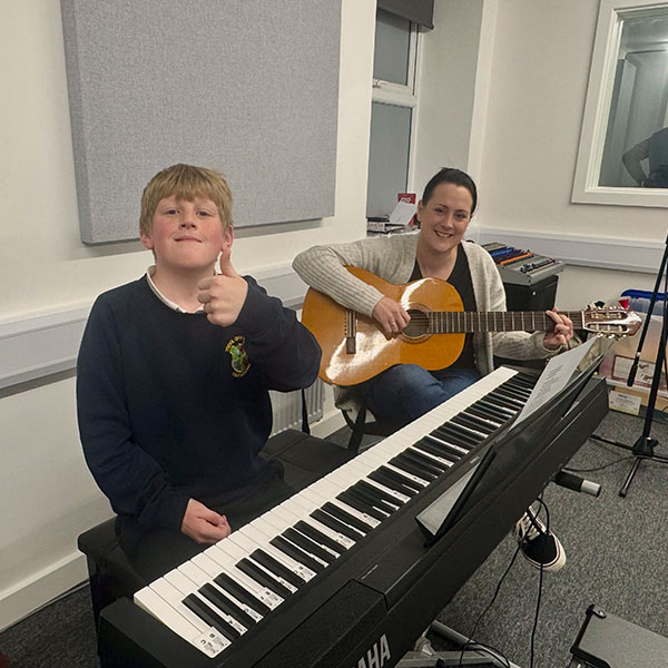 Young boy learning to play keyboard at Wrexham Sounds